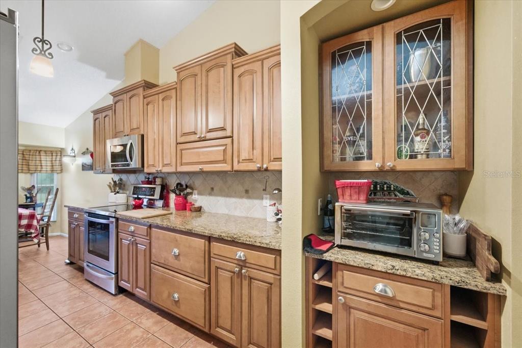 9338 Clearmeadow New Port Richey, FL 34655 - Photo 17 of 54 a kitchen with stainless steel appliances granite countertop a stove sink and cabinets