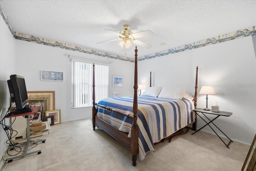 9338 Clearmeadow New Port Richey, FL 34655 - Photo 27 of 54 a bedroom with a bed and a chandelier