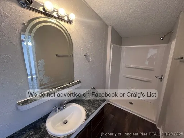a bathroom with a granite countertop sink a mirror and a toilet