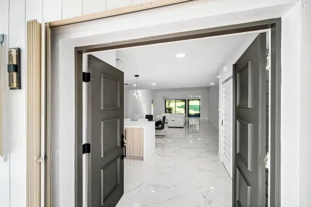 a living room with furniture flat screen tv and a large window