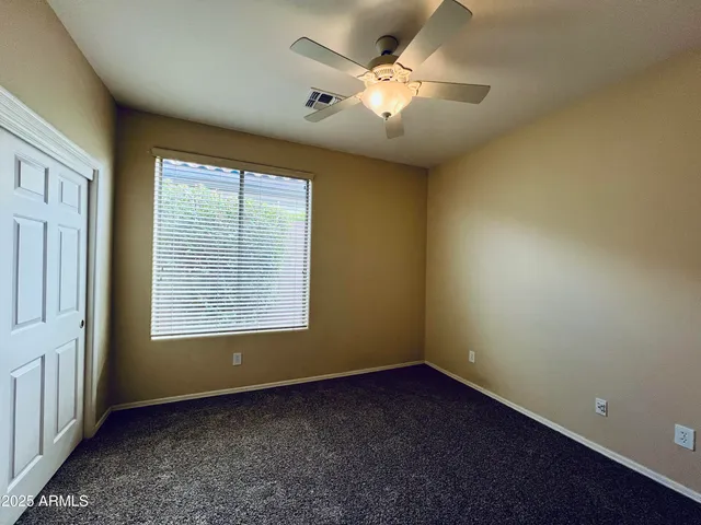 an empty room with a window and a fan