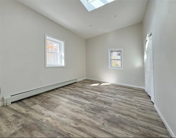 a view of empty room with wooden floor
