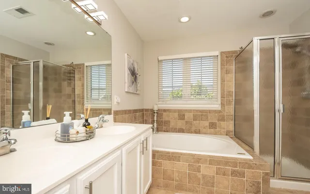 a bathroom with a tub sink and mirror