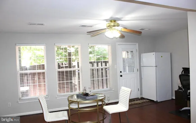 a view of a dining room with furniture a chandelier and large window