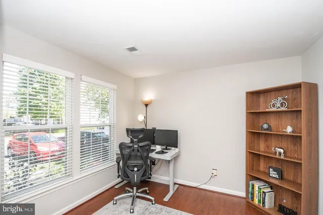 a view of a workspace with furniture and a window