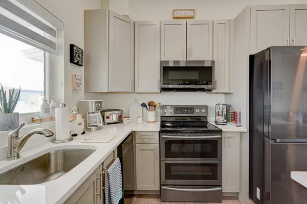 a kitchen with stainless steel appliances a stove a sink and a microwave