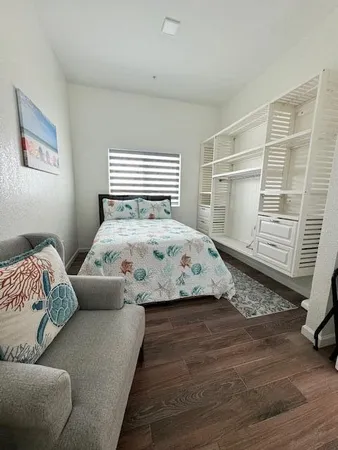 a bedroom with a bed and wooden floor