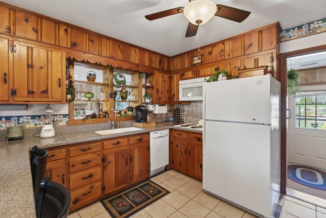 9625 Town Hall Road McGaheysville, VA 22840 - Photo 25 of 65 a kitchen with stainless steel appliances granite countertop a refrigerator a sink and white cabinets