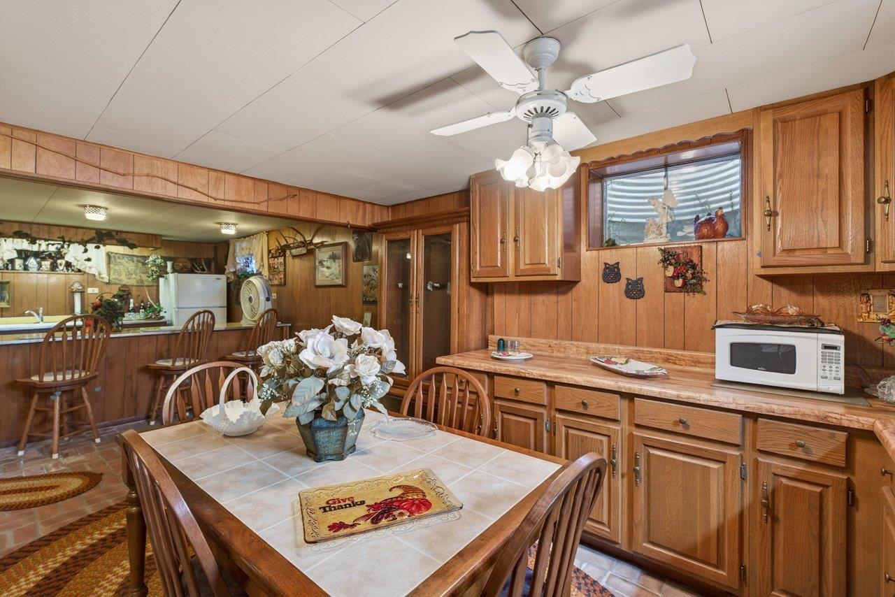 9625 Town Hall Road McGaheysville, VA 22840 - Photo 42 of 65 a kitchen with stainless steel appliances granite countertop a stove a sink dishwasher a dining table and chairs with wooden floor