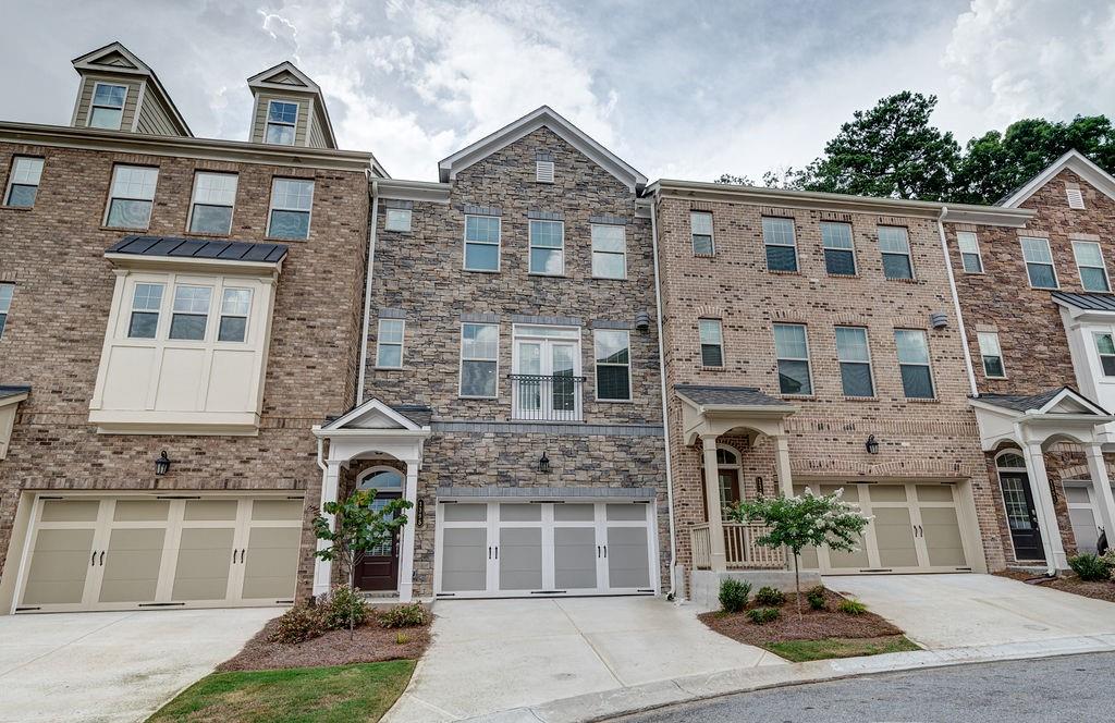 a front view of a building with a garden and plants