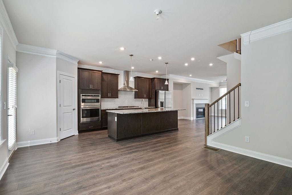 1395 Harris Way Street Brookhaven, GA 30319 - Photo 12 of 28 a large kitchen with stainless steel appliances kitchen island granite countertop a large counter top and wooden floors