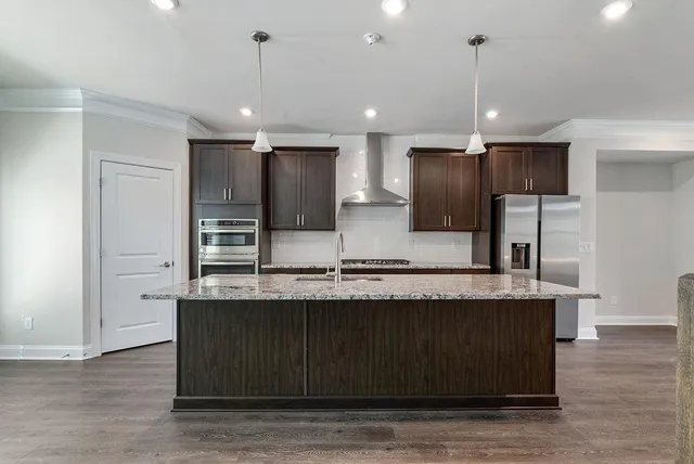 a view of a kitchen with kitchen island a counter top stainless steel appliances and cabinets