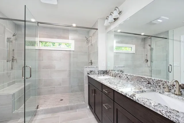 a bathroom with a shower sink and mirror