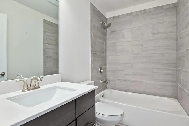 a bathroom with a granite countertop sink toilet and bathtub