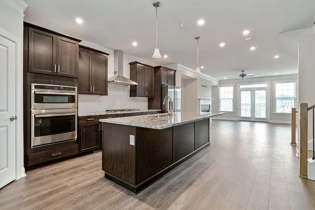 a kitchen with stainless steel appliances granite countertop a stove a sink and a refrigerator