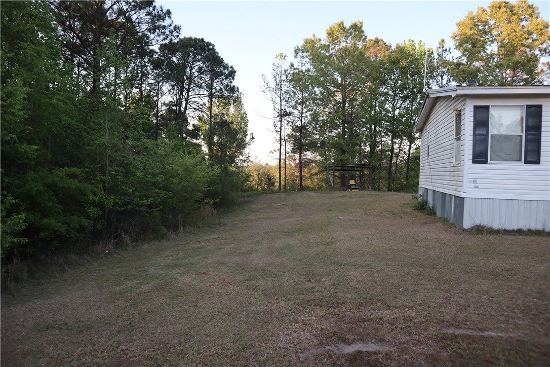 100 Powerline Road Auburn, AL 36830 - Photo 5 of 9 This tranquil setting offers a spacious yard beside a cozy dwelling.
