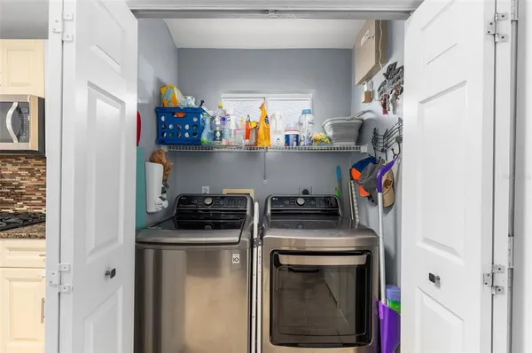a utility room with stainless steel appliances granite countertop a stove and a refrigerator