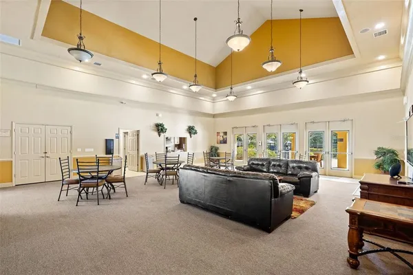a living room with furniture a chandelier and kitchen view