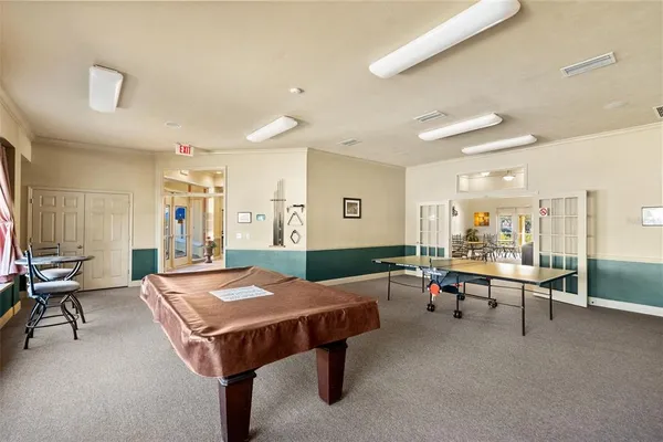 a living room with furniture pool table and a window