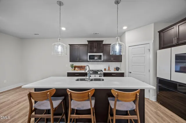 a kitchen with refrigerator cabinets and wooden floor