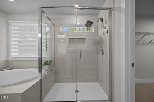 a white bath tub sitting in a bathroom next to a window