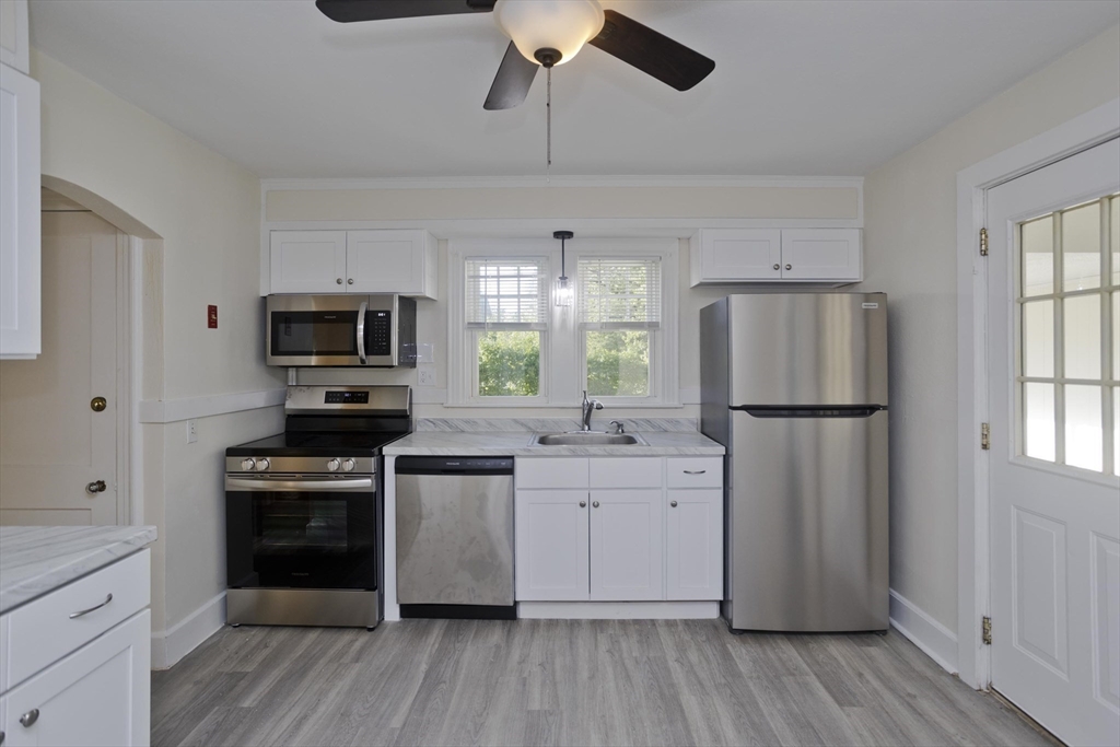 1350 Wilbraham Road Springfield, MA 01119 - Photo 4 of 35 a kitchen with a refrigerator a sink dishwasher a stove and a microwave oven with wooden floor