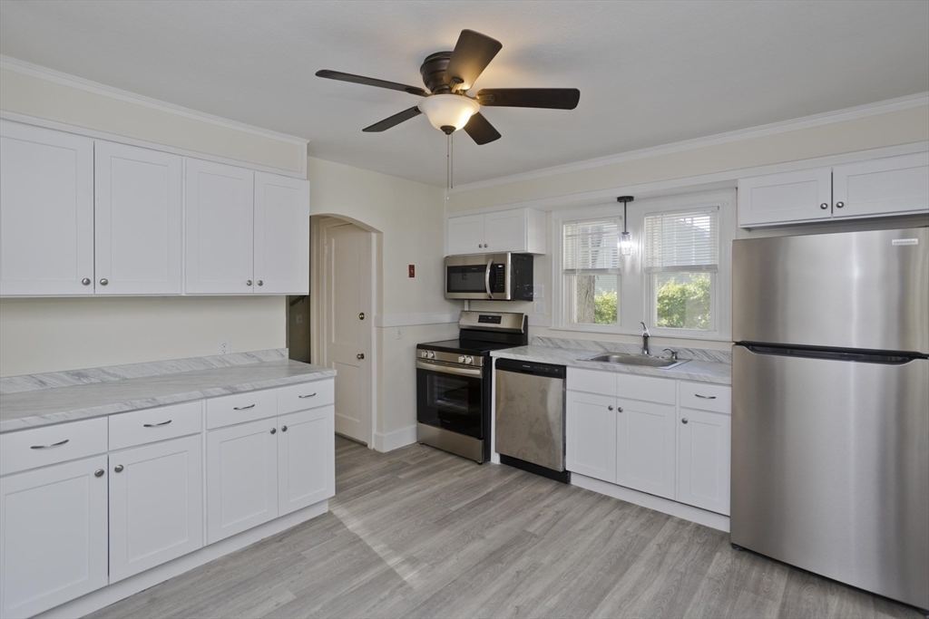 1350 Wilbraham Road Springfield, MA 01119 - Photo 5 of 35 a kitchen with white cabinets and stainless steel appliances