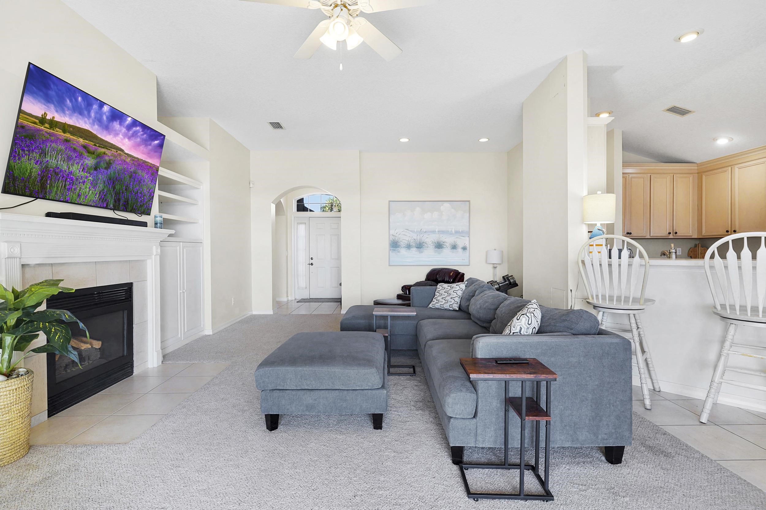 338 South Ocean Trace Road St. Augustine, FL 32080 - Photo 11 of 41 a living room with furniture a flat screen tv and a fireplace