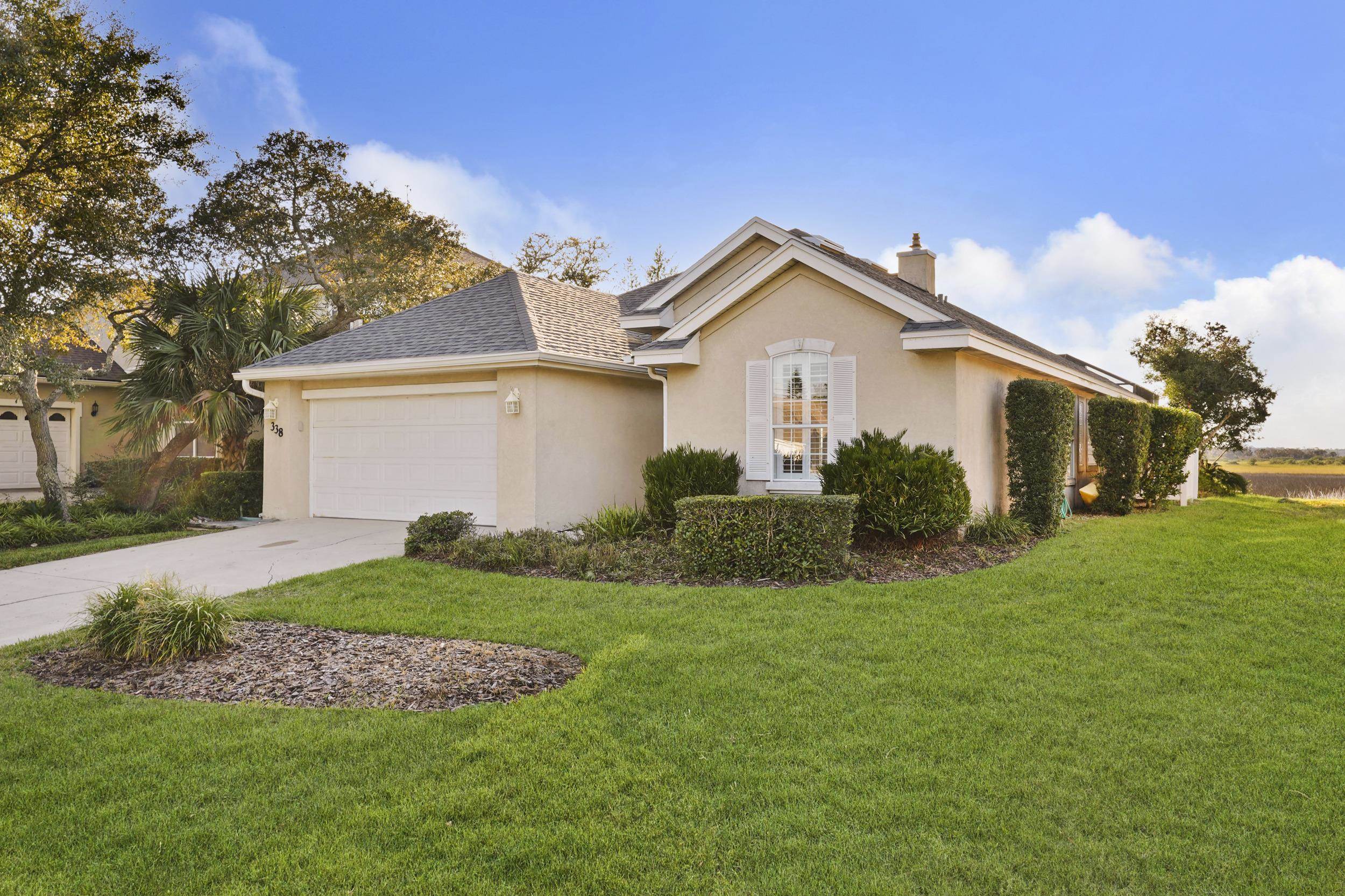 338 South Ocean Trace Road St. Augustine, FL 32080 - Photo 2 of 41 a front view of a house with a yard and garage