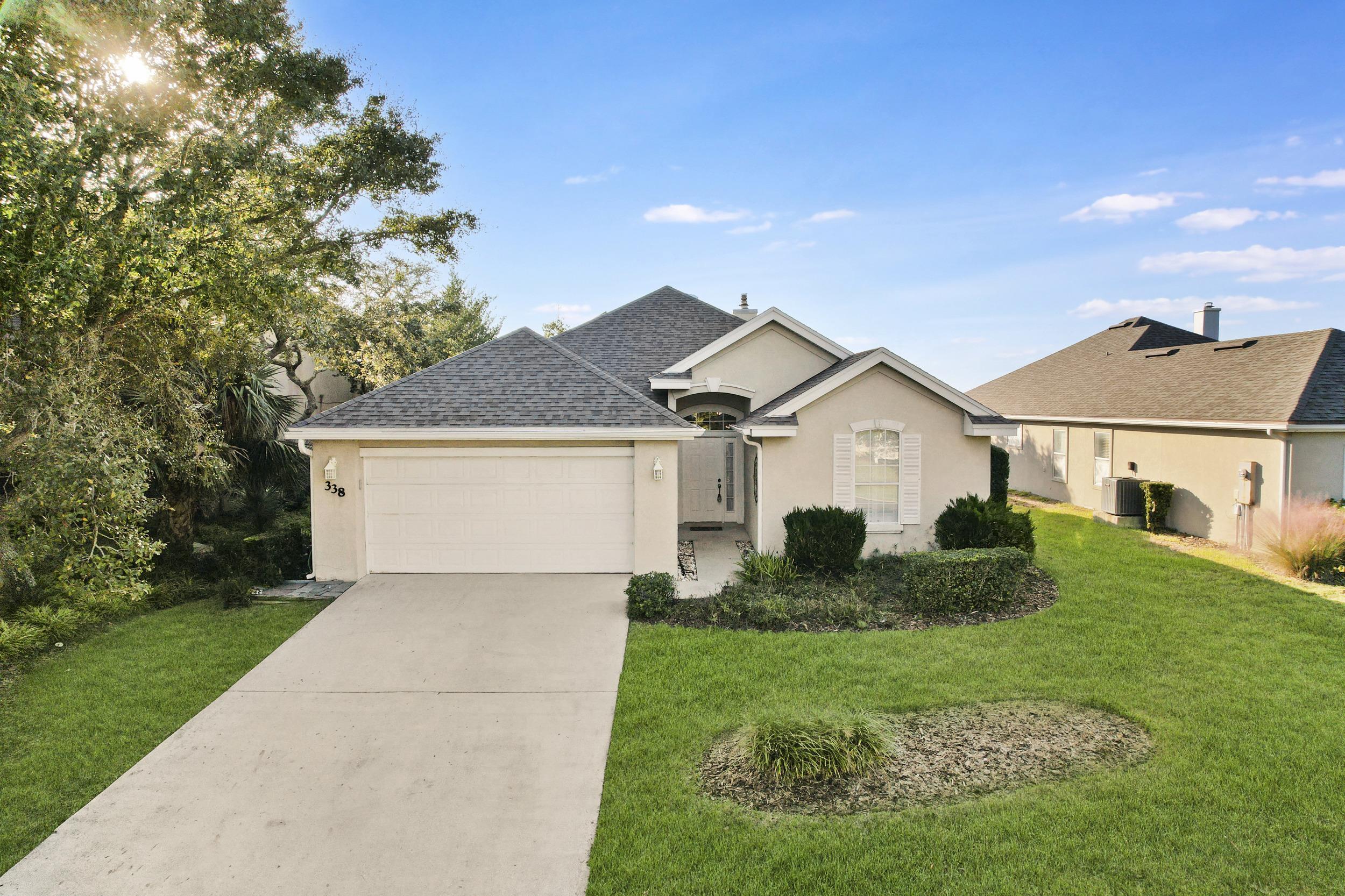 338 South Ocean Trace Road St. Augustine, FL 32080 - Photo 3 of 41 a front view of a house with a yard and garage