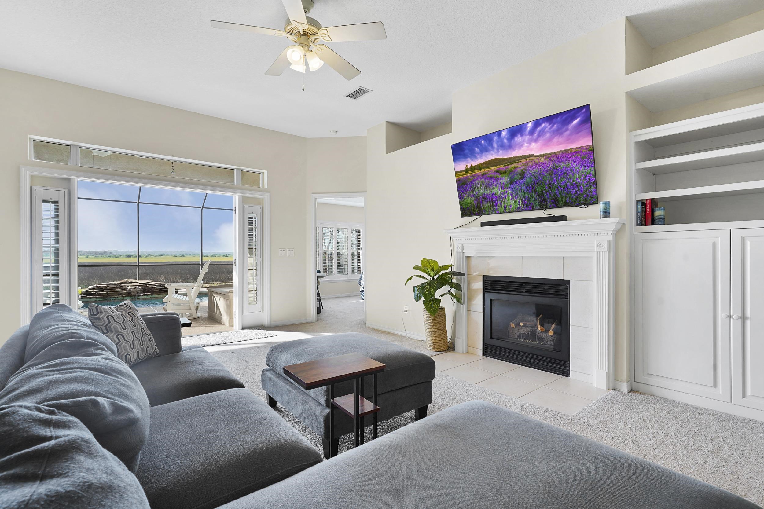 338 South Ocean Trace Road St. Augustine, FL 32080 - Photo 10 of 41 a living room with furniture a flat screen tv and a fireplace