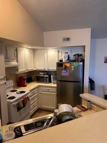 a kitchen with a refrigerator and a stove top oven