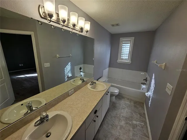 a bathroom with a tub sink and mirror