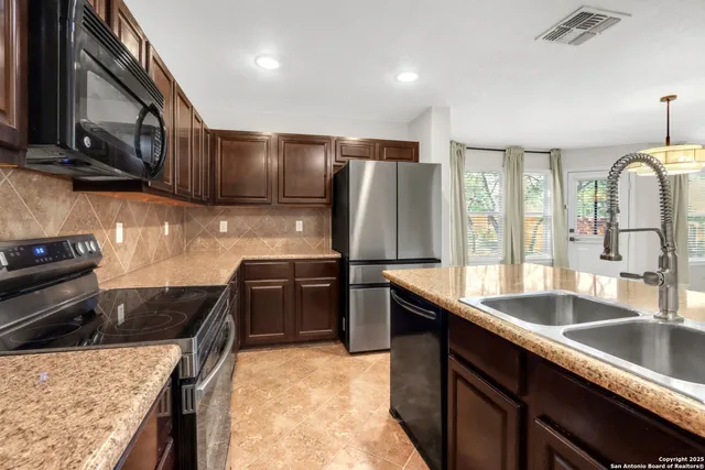 a kitchen with stainless steel appliances granite countertop a sink stove and refrigerator