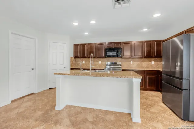 a kitchen with stainless steel appliances granite countertop a sink stove and refrigerator