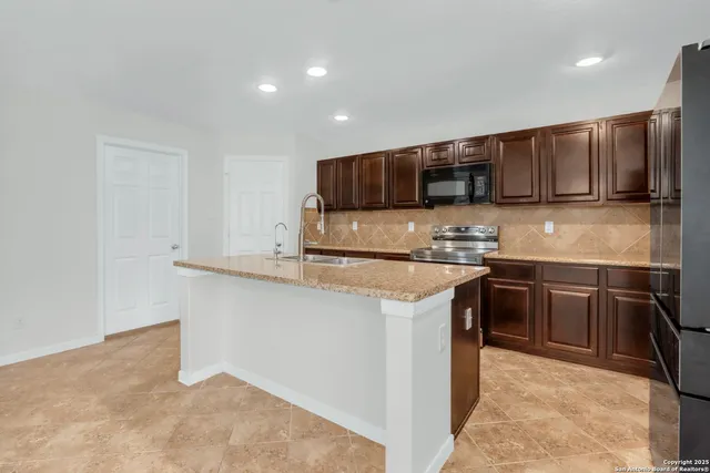 a kitchen with stainless steel appliances granite countertop a sink stove and refrigerator