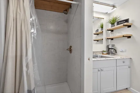 a view of a hallway with wooden floor and cabinet