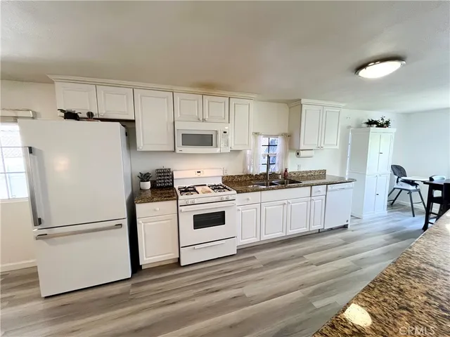 a kitchen with white cabinets and white appliances