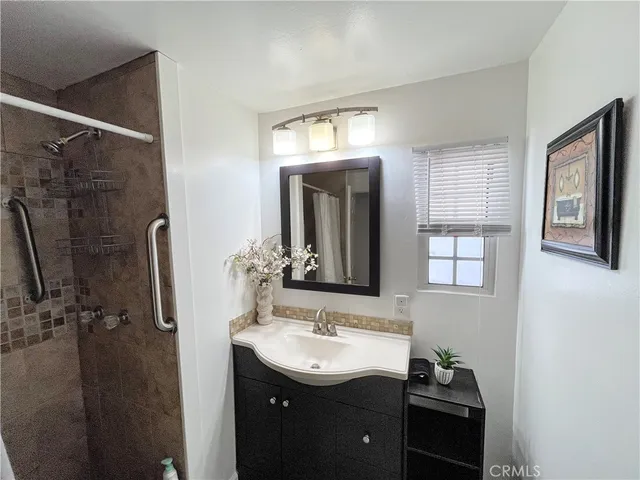 a bathroom with a sink a mirror and shower