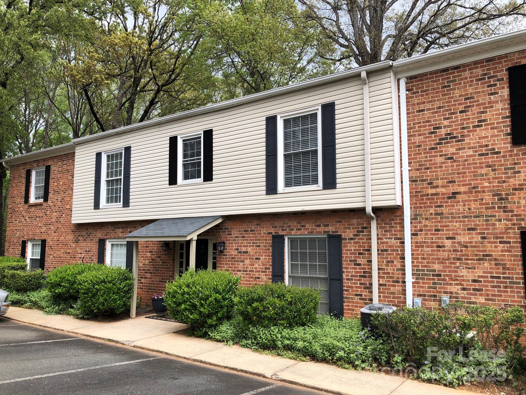 5925 Quail Hollow Road, Unit D Charlotte, NC 28210 - Photo 1 of 17 a front view of a house with yard and green space