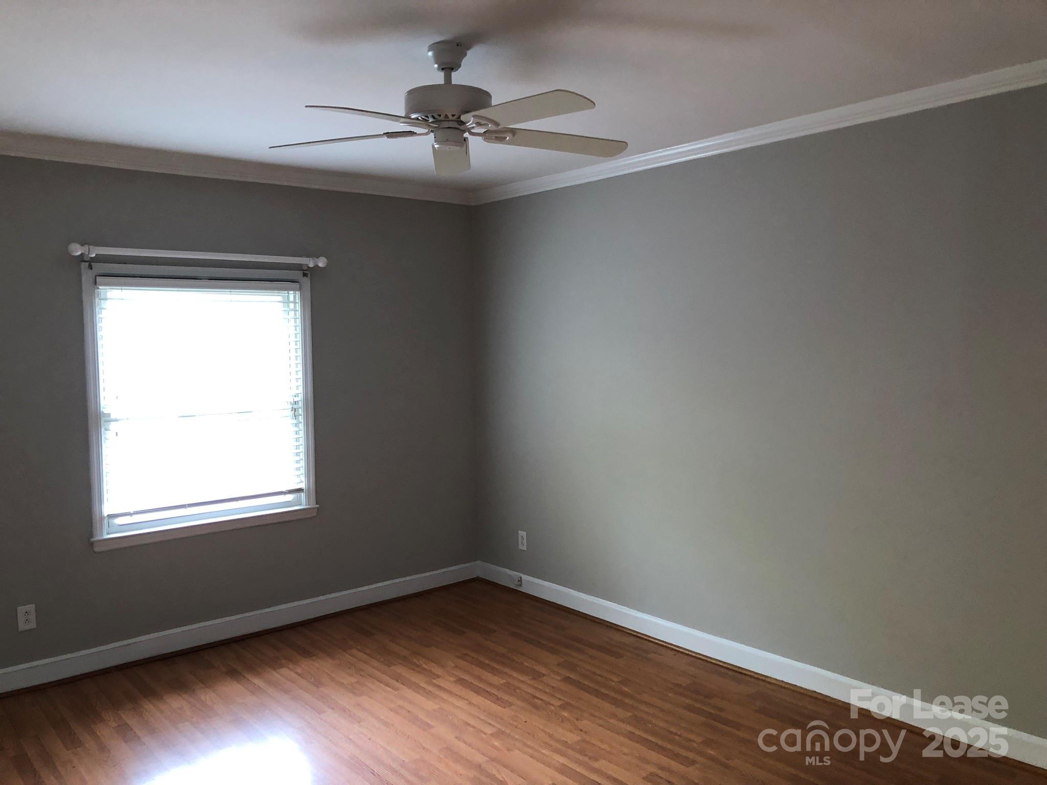 5925 Quail Hollow Road, Unit D Charlotte, NC 28210 - Photo 13 of 17 a view of an empty room with wooden floor and a window