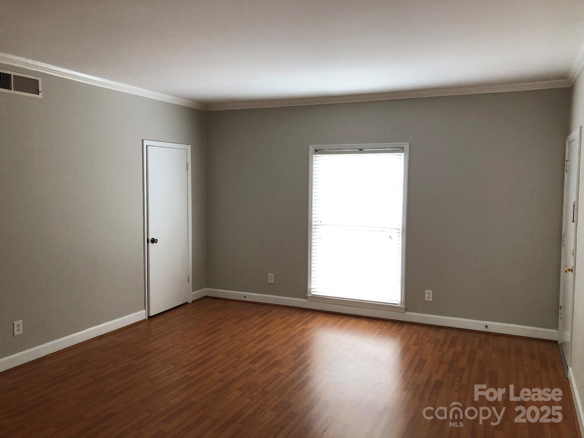 5925 Quail Hollow Road, Unit D Charlotte, NC 28210 - Photo 3 of 17 an empty room with wooden floor and windows