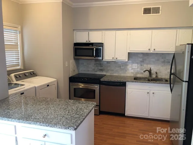 a kitchen with stainless steel appliances granite countertop a sink stove and microwave