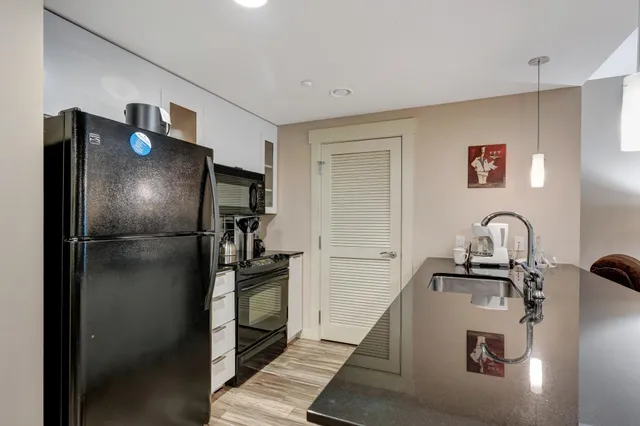 a kitchen with granite countertop a stove sink and microwave