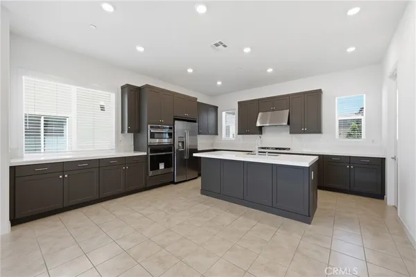 a kitchen with stainless steel appliances a sink a stove a microwave and cabinets