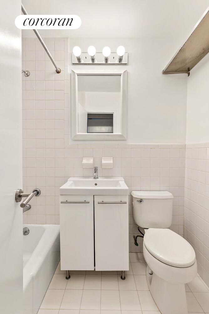 305 East 24th Street, Unit 5S Manhattan, NY 10010 - Photo 6 of 8 a bathroom with a toilet a sink and mirror