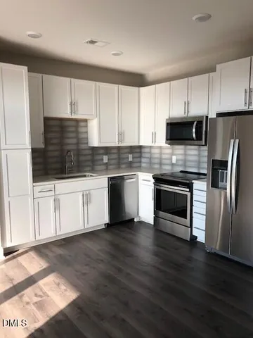 a kitchen with wooden cabinets and stainless steel appliances