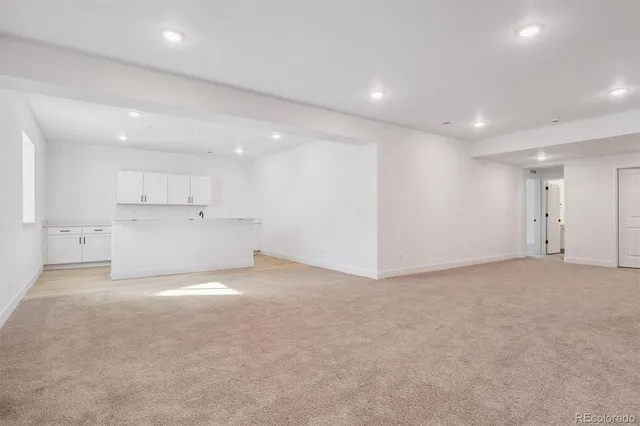 a view of an empty room with a kitchen