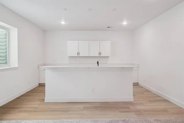 a view of kitchen cabinets and wooden floor