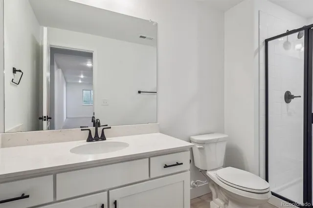 a bathroom with a sink toilet vanity and shower